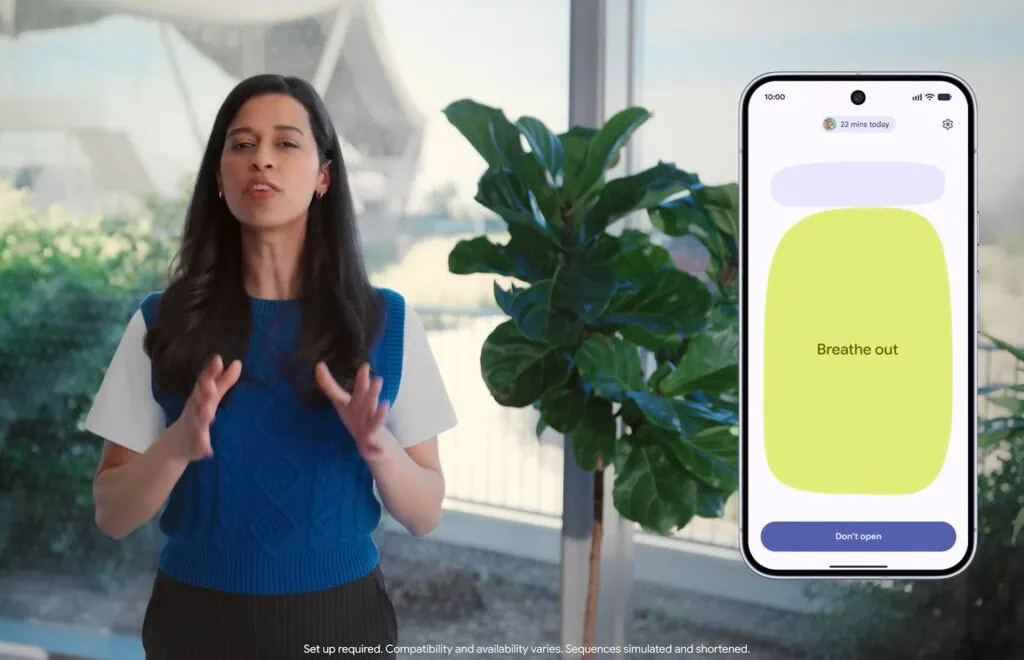 Android show 2026: veja tudo que o google lançou! Apresentadora ao lado de smartphone exibindo a tela do recurso pause point com mensagem "breathe out" (expire) em fundo verde, parte da funcionalidade de controle de tempo de tela do android 17