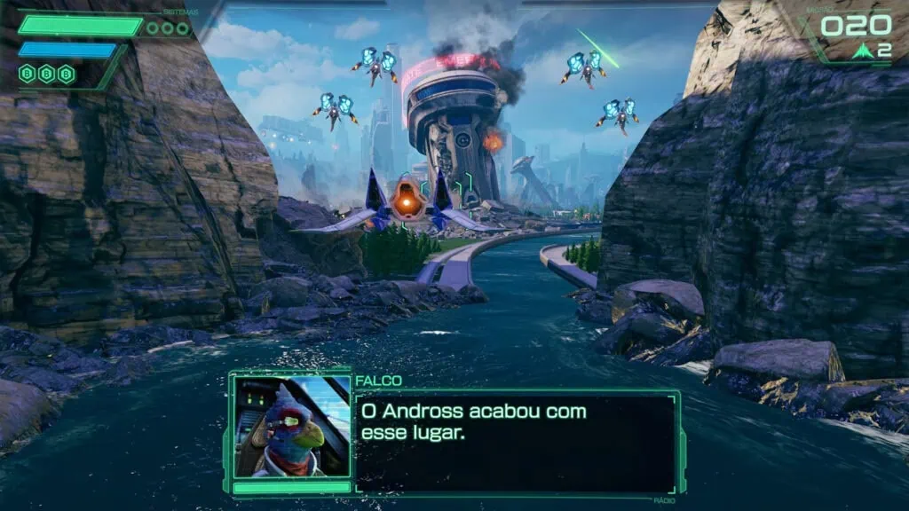 Nintendo anuncia star fox para switch 2 com remake do clássico n64 Tela de gameplay do jogo star fox para switch 2 mostrando nave arwing voando sobre rio entre formações rochosas, com torre futurista em chamas ao fundo e quatro naves inimigas com luzes azuis. Interface exibe barras de sistema no canto superior esquerdo e caixa de diálogo com personagem falco na parte inferior dizendo 'o andross acabou com esse lugar