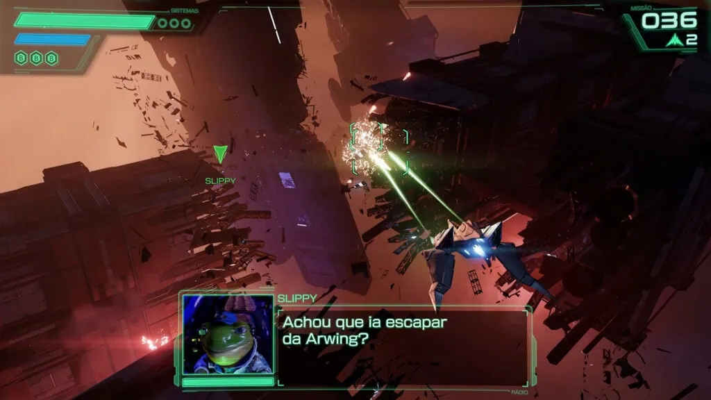 Nintendo anuncia star fox para switch 2 com remake do clássico n64 Captura de gameplay de star fox para nintendo switch 2 mostrando combate em corredor industrial estreito, cheio de destroços metálicos e faíscas sob iluminação alaranjada. A nave do jogador dispara dois raios laser verdes contra alvos à frente. Interface exibe barras de 'sistemas' e indicadores de bomba ('b b b') no canto superior esquerdo, e pontuação '036' com '2' vidas no canto superior direito. Um marcador verde aponta para a posição do companheiro 'slippy'. Na parte inferior, caixa de comunicação exibe o rosto 3d de slippy toad com a legenda em português: 'achou que ia escapar da arwing?