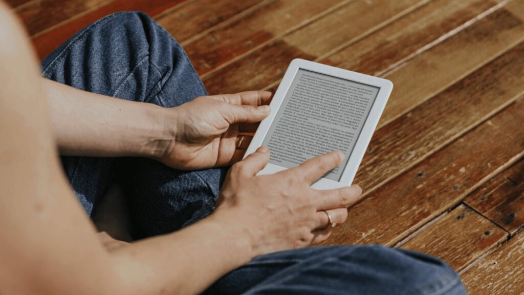 មនុស្សម្នាក់កំពុងប្រើ Kindle