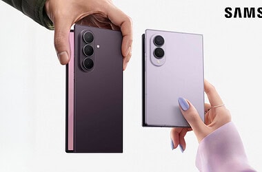 Duas mãos seguram os novos dobráveis anunciados no galaxy unpacked lado a lado, o galaxy z fold8 ultra com três câmeras à esquerda e o galaxy z fold8 com duas câmeras à direita, com o logo da samsung ao fundo