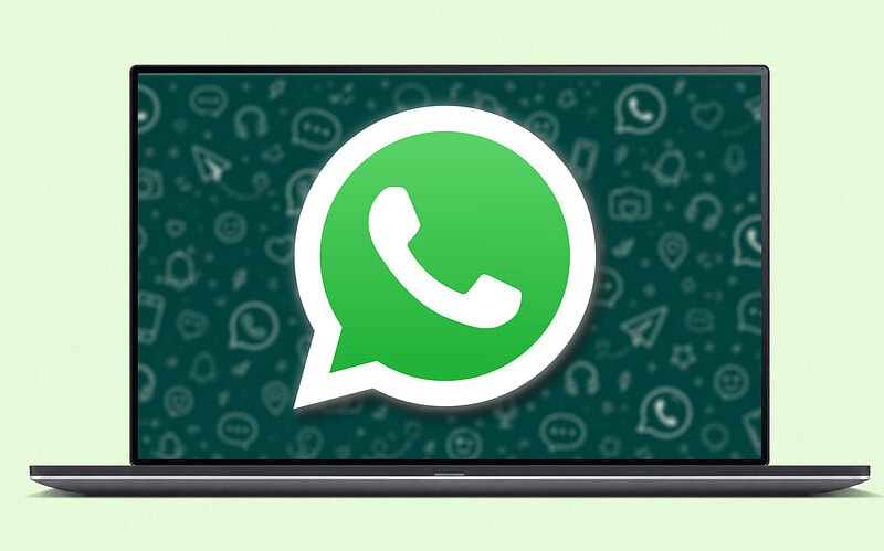 Notebook aberto com o logotipo do mensageiro em destaque na tela sobre um fundo verde de ícones, ilustração principal das dicas do whatsapp web.