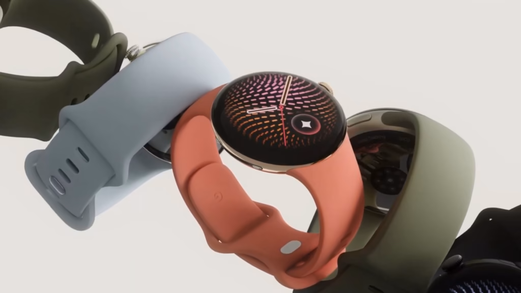 Google lança pixel watch 5 e pixel tag no made by google 2026 Quatro pixel watch 5 com pulseiras em preto, azul-claro, coral e verde, exibidos sobre fundo claro.