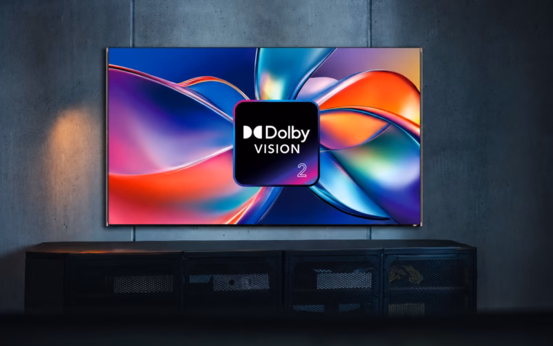 Smart tv exibindo o logo dolby vision 2 sobre formas coloridas abstratas em uma sala escura.