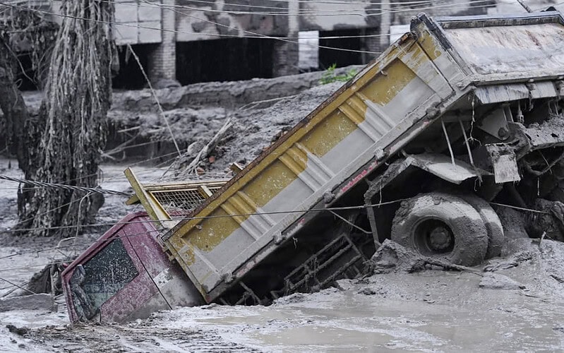 Caminhão parcialmente soterrado por lama após enchente em rasuwa, no nepal.